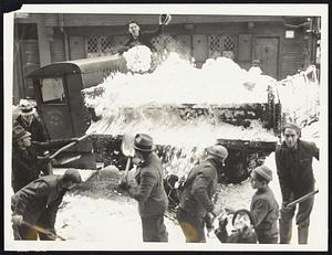 Shovellers shown unravelling the blanked of snow which covered Boston's streets. The little fellow, front right, assists in his won peculiar way.