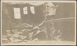 Interior of burned building after fire, with firemen present