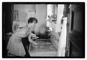 A woman doing laundry at a sink