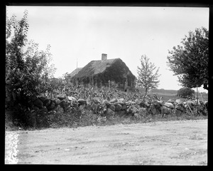 Stone wall and vine covered house, N.H.