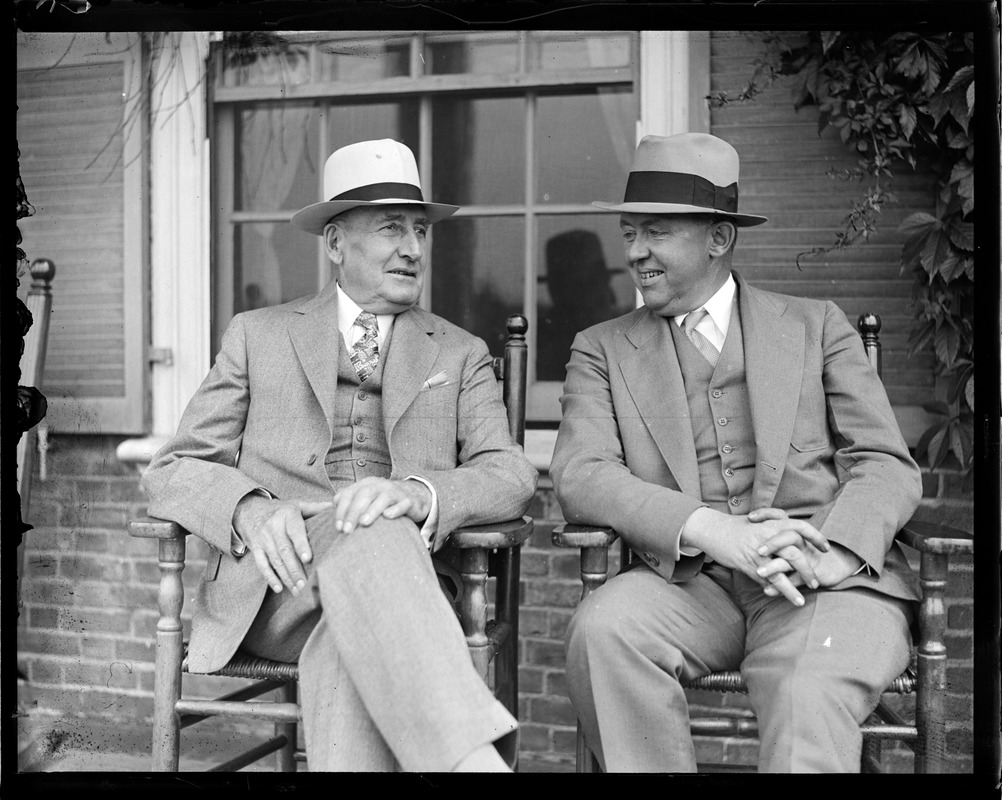 Two men talk on porch