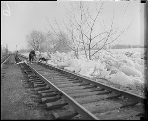 Clearing ice off railroad tracks, during flood