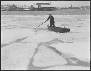 Man pushes boat through ice, unidentified harbor
