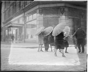Women use umbrellas to ward off snow, during snowstorm in downtown Boston