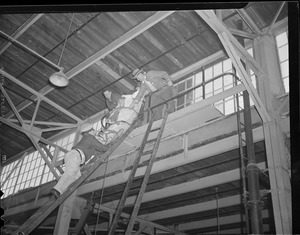 Injured man being lowered by rescuers in warehouse.