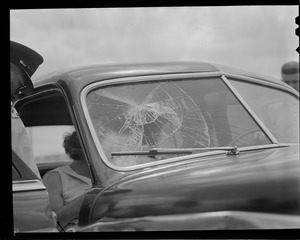 Policeman attending woman in car.