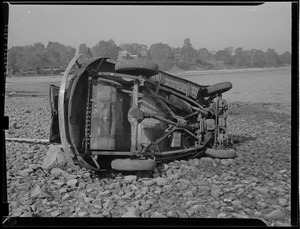 Overturned auto on beach.