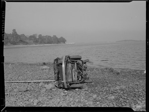 Overturned auto on beach.