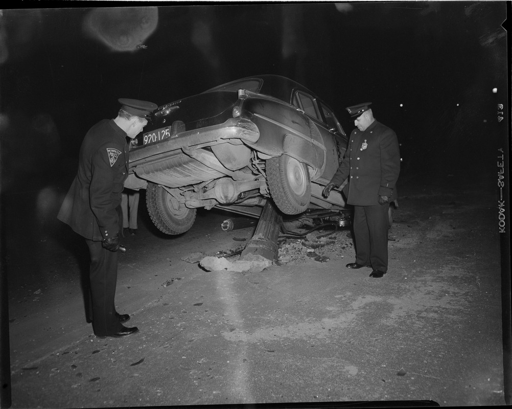 Police inspect car after crash into pole