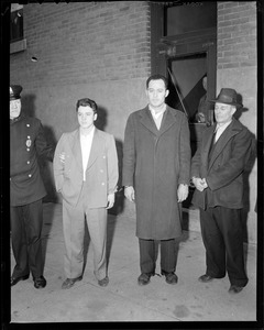 Patrolman with three men in handcuffs