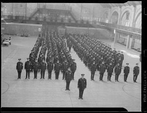 Uniformed police at attention in drill hall at armory