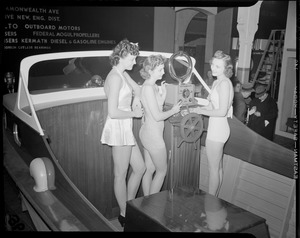 Bathing beauties aboard motor boat at boat show