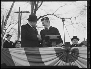 Men shake hands on reviewing stand