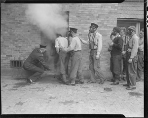 Firemen in gas masks get ready to enter smoke filled building during training