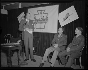 Frederic C. Church, Jr., speaks at induction of Boys' Club of Boston members into the Victory Volunteers while Pfc. Hy Rosen and Col. George A. Ford watch at Jordan Marsh Co. Auditorium