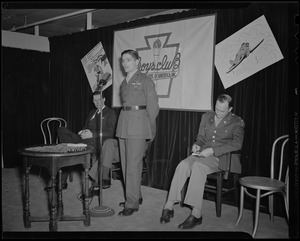 Pfc. Hy Rosen speaks at induction of Boys' Club of Boston members into the Victory Volunteers while Boston Mayor Maurice Tobin, Frederic C. Church, Jr., and Col. George A. Ford watch at Jordan Marsh Co. Auditorium