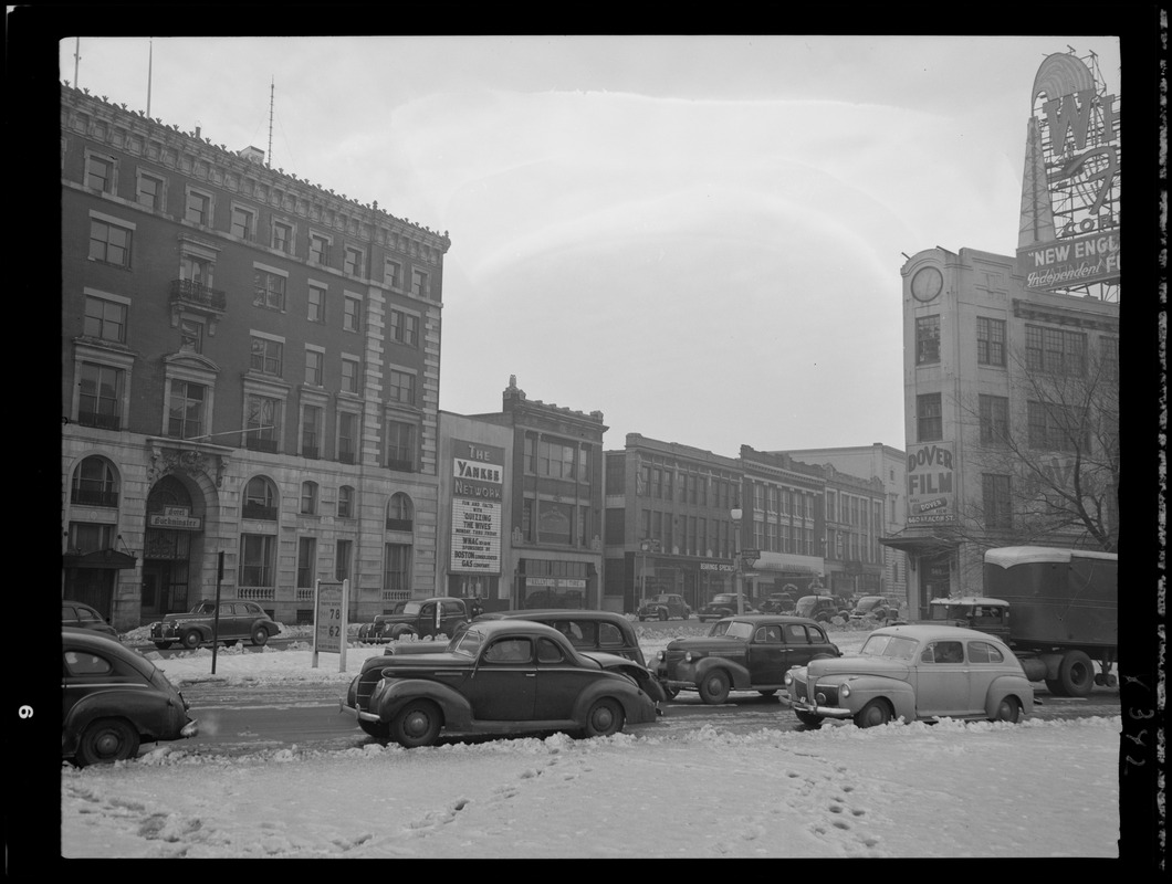 Street scene with Yankee Network letter board sign advertising Quizzing the Wives on WNAC sponsored by Boston Consolidated Gas Company