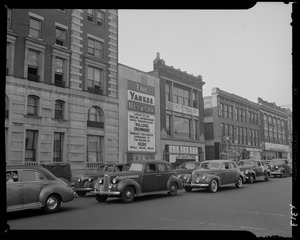Street scene with Yankee Network letter board sign advertising Bulldog Drummond on WNAC sponsored by Hush