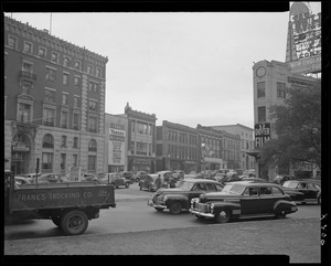 Street scene with Yankee Network letter board sign advertising Quiz of Two Cities on WNAC sponsored by Listerine toothpaste