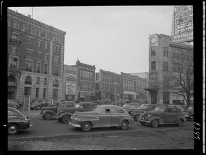 Street scene with Yankee Network letter board sign advertising The Answer Man on WNAC sponsored by Gilchrist's