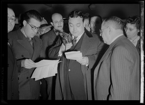 Man speaking into WCOP microphone surrounded by people including Russell Offhaus