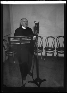 Priest standing at WCOP microphone