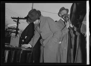 Two men using WCOP radio equipment outside