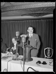 Man speaking from dais into WAAB microphone at the Statler Hotel