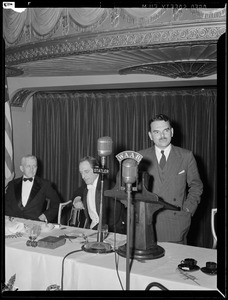 Man speaking from dais into WAAB microphone at the Statler Hotel