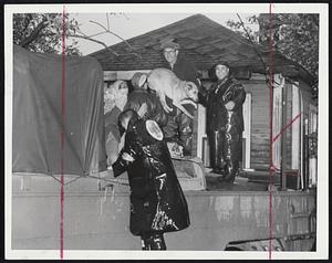 Rescued From Revere Home--Red Cross Disaster workers assist the family--and dog-- of Mr. and Mrs. Stanley Melillo at 94 Dunn Rd., as flood waters lapped against the threshold of their home yesterday. The privately-owned rescue craft was sped to the scene from Braintree to assist in the evacuation.