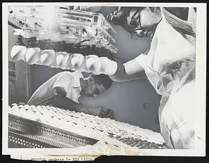 Medical workers in the Eli Lilly and Co., laboratories at Greenfield, Ind., place rows of eggs, ready for vaccine production, into incubators at a hatchery.
