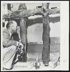 State Investigator H. E. Sims examines two unburned crosses at Anniston, Ala. Two similar ones were set afire there Saturday. A Ku Klux official said they were answer to Negro sit-down.