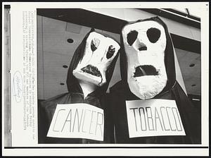 Tobacco Protest--Two pickets parade outside the Federal Communications Commission Building in Washington Friday protesting a hearing between the FCC and members of the tobacco industry.