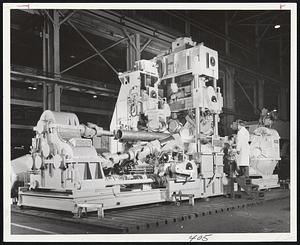 Industrially, That Is-This giant machine, in the Wheeling, W. Va., plant of Blaw-Knox Co. straightens pieces of pipe up to 24 inches in diamater. This particular machine works on extruded magnesium tubing.