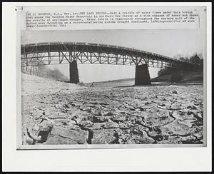 Dry Land Bridge--Only a trickle of water flows under this bridge that spans the Boonton Water Reservoir in northern New Jersey as a wide expense of baked mud shows the results of prolonged drought. Water levels in reservoirs throughout the eastern half of the nation were dwindling as a record-shattering autumn drought continued.