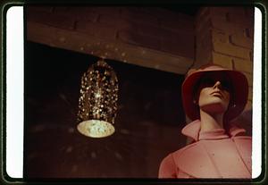 A light fixture behind a mannequin