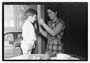 Maude Sanromá feeding a boy