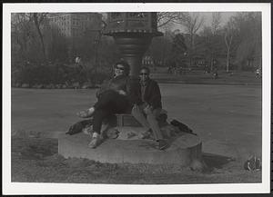 Two women sitting on the base of the Japanese Lantern sculpture in the Boston Public Garden