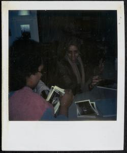 Two women looking at photographs