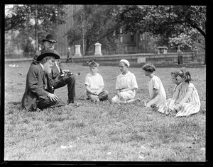 P.R. Barker, GAR vet from Fitzgerald, Georgia, tells kiddies stories that makes their hair stand on end, with him is vet John Houder, also from Fitzgerald. They are on historic Boston Common.