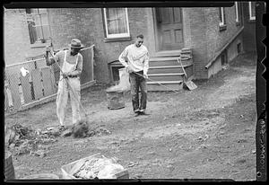 Two men working in a yard