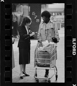 Market researcher interviews customers at shopping mall in Brighton