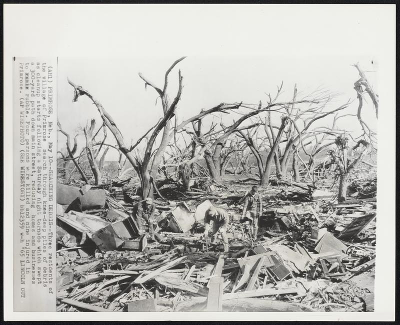 Primrose, Neb. – Searching Debris – Three residents of the village of Primrose search through knee-deep piles of debris as cleanup starts following a Saturday night tornado which swept a 300-yard path down main street, reducing homes and businesses to rubble. Four persons were killed and nine injured in Primrose.