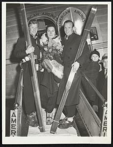 Norwegian Skiers in Chicago. Skis and all Mr. and Mrs. Birg Ruud and Sigmund Ruud (L. to R.) shown as they arrived in Chicago by plane, Jan.15, en route to the ski tourney at Cary, Ill., Jan. 16. In 200 meets Birger has set 50 records, has come in first 110 times.