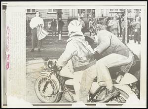 Patriotic Challenge--An unidentified spectator stands at upper left with the American flag he had just torn from the hands of youth on the motorcycle. The youths had been taunting Co[lo]rado National Guardsmen at upper right. Guardsmen and Denver Police onto the Denver University campus before dawn to tear down the shantytown erected by demonstrators. There was no violence, both youths arrested by police. The spectator said "this flag means so much to me."