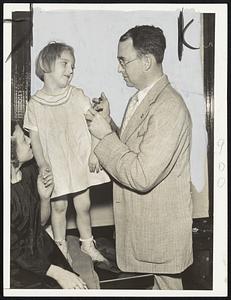 In Ware, Dr. Tracy L. Roberson is shown innoculating a young flood refugee. This Traveler photo was the first to get out of the isolated town.