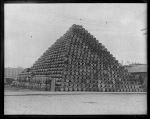 Mackerel barrels, fish pier. Empty barrels piled up in pyramid shape at South Boston fish pier to be used for fishing industry.
