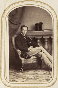 Portrait of a  seated man holding a cane and gloves