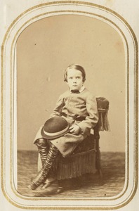 Portrait of a boy holding a hat