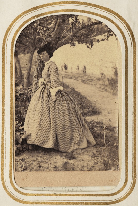 Portrait of a woman in a hat under a tree